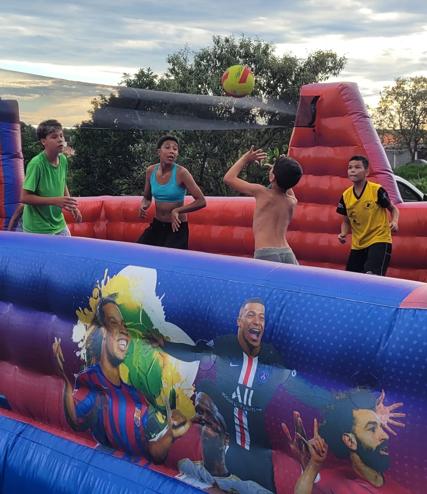 Crianças brincando na quadra esportiva inflável